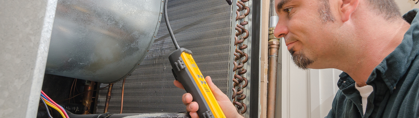 A technician performing an air conditioning repair service in Philadelphia, PA